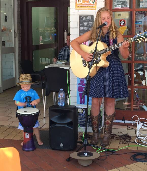 Shalani Thomas busking in Tamworth with her two-year-old brother Mackallay. The 13-year-old Bulli performer took out first place in her category at a national talent show this week.