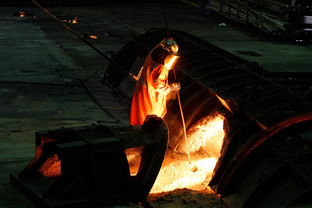 A Port Kembla worker oversees the flow of molten iron from the blast furnace. Picture: Sylvia Liber.