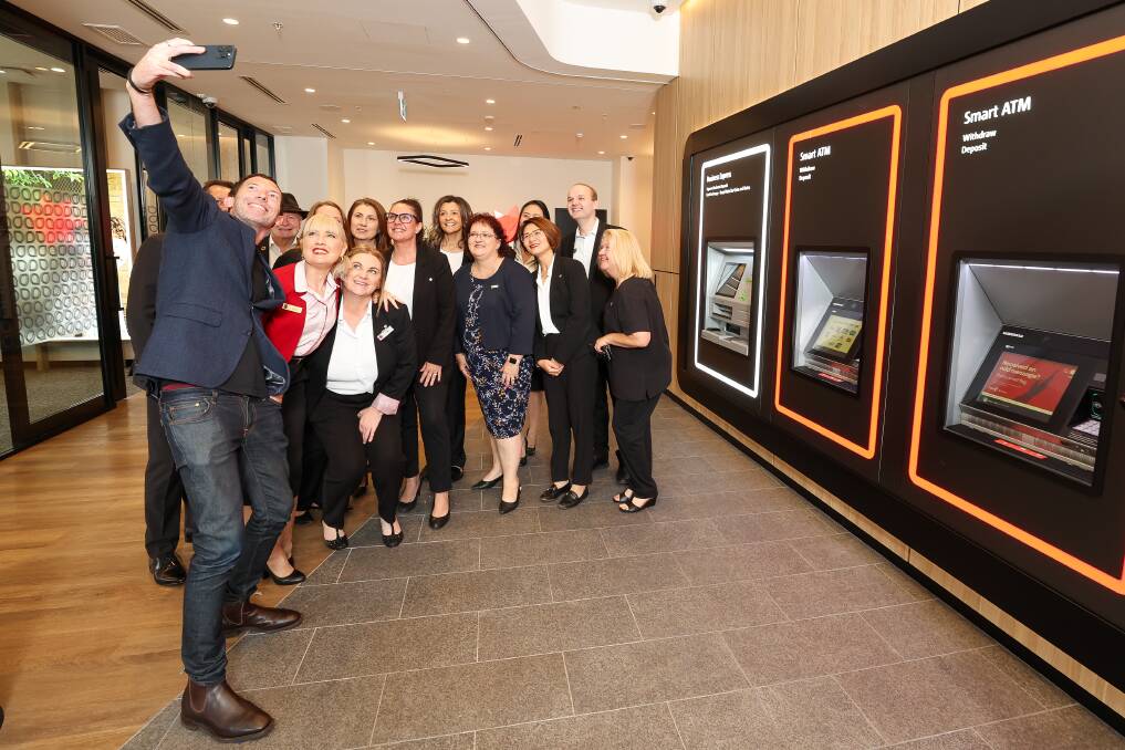Tony Story from the NAB's NSW/ACT executive retail team takes a selfie with staff at the new branch in Langs Corner that opened on Friday. Picture by Adam McLean