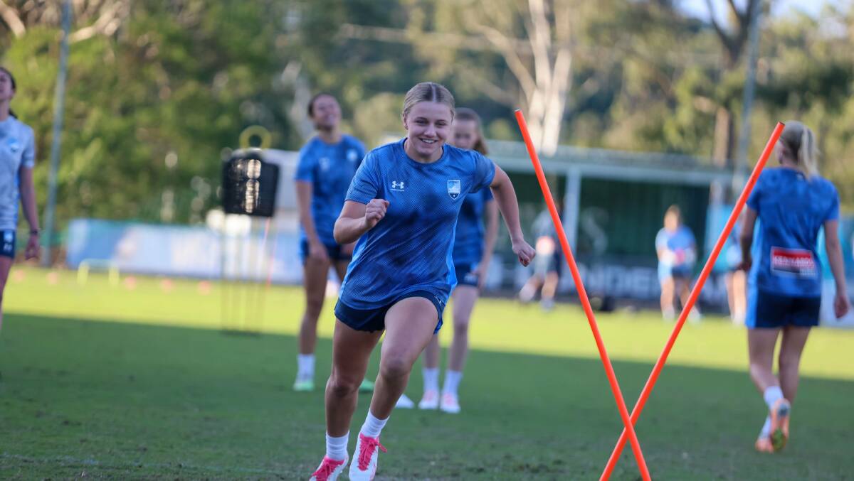 Caley Tallon-Henniker smiles while running through a sky blues' training drill. Picture - Sydney FC