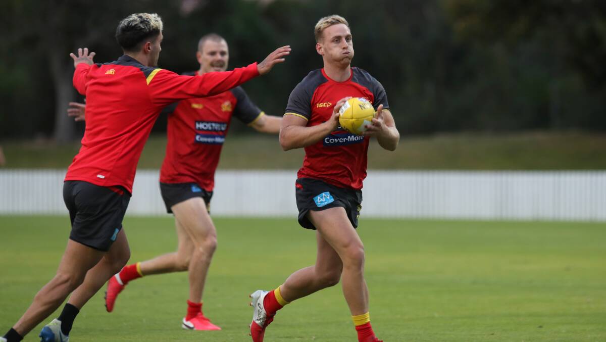 Gold Coast players run through a training drill at North Dalton Park on Friday afternoon. Picture: Sylvia Liber
