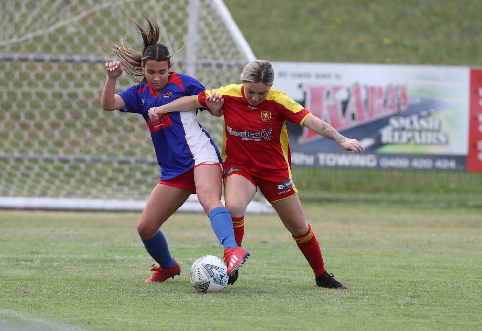 CHALLENGE: Woonona's Kyah Humphrey (left) battles for possession during a Women's Division One game last weekend. Picture: Robert Peet