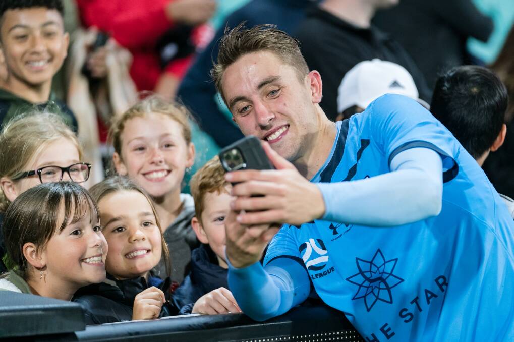 HAPPY: Joel King poses for a photo with some young Sydney FC fans. Picture: Jaime Castaneda