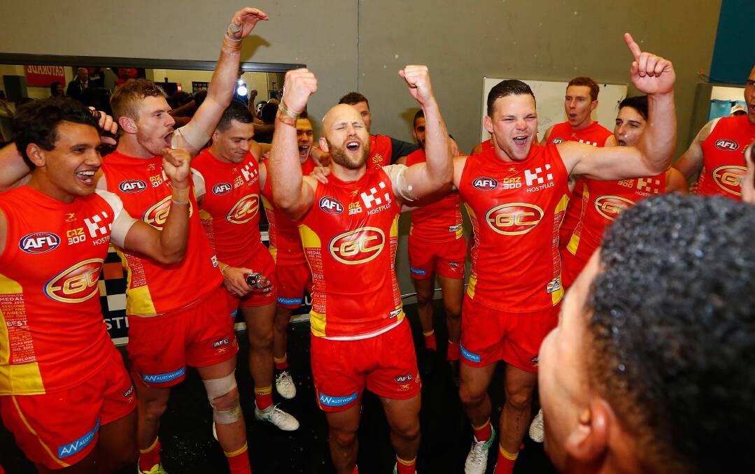 Loud and proud: The "Little Master" Gary Ablett (centre) leads the team song as the Gold Coast Suns celebrate victory. Picture: Jason O'Brien/AFL Media via Getty Images