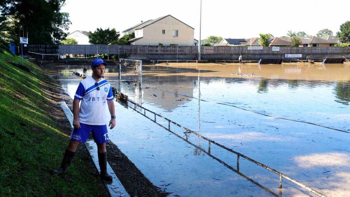 Bulli FC club members and volunteers work hard to clean up the flood and storm damage at Balls Paddock on Sunday. Pictures by Sylvia Liber