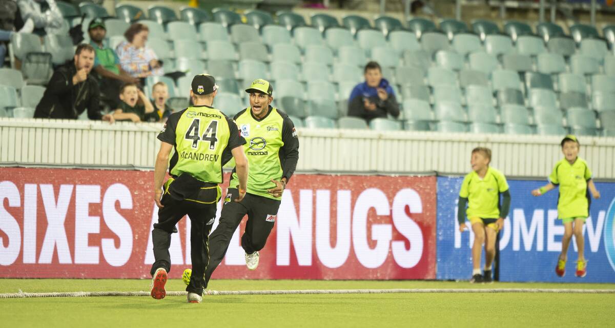 Nathan McAndrew (front) congratulates Sydney Thunder teammate Jason Sangha after taking a catch against the Melbourne Stars at Manuka Oval in December 2018. Picture: Sitthixay Ditthavong