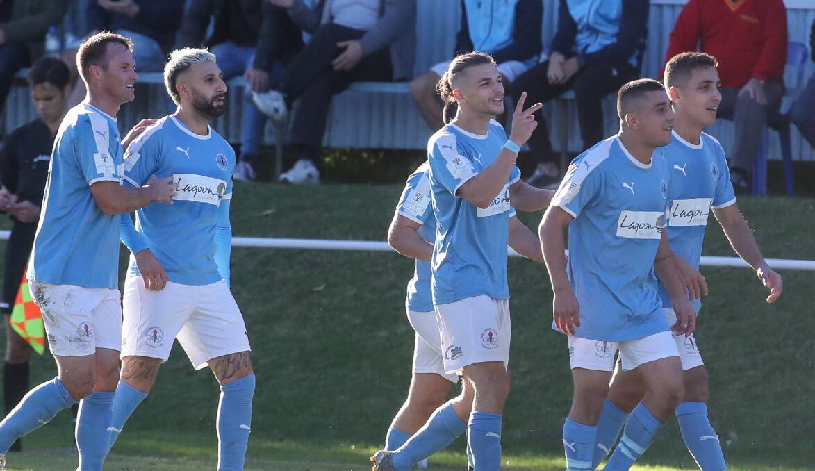 Wollongong Olympic's Tory Musumeci (centre) celebrates with teammates after scoring his second goal against United. Picture: Adam McLean