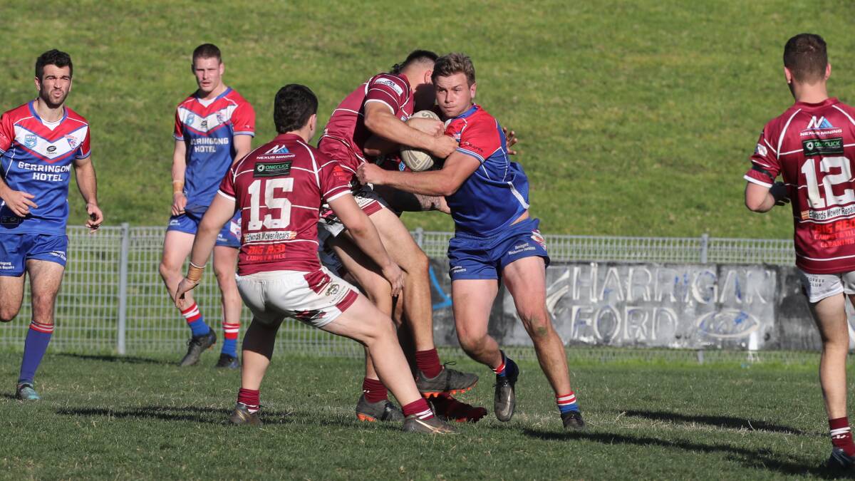 STANDING TALL: Gerringong player Danny Wedd is wrapped up in a strong tackle on Sunday. Picture: Robert Peet