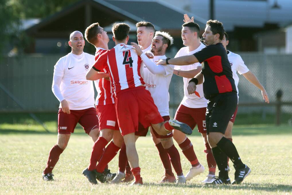 GAME ON: Things get a little heated between Oak Flats Falcons and Unanderra Hearts players on Saturday afternoon. Pictures: Sylvia Liber
