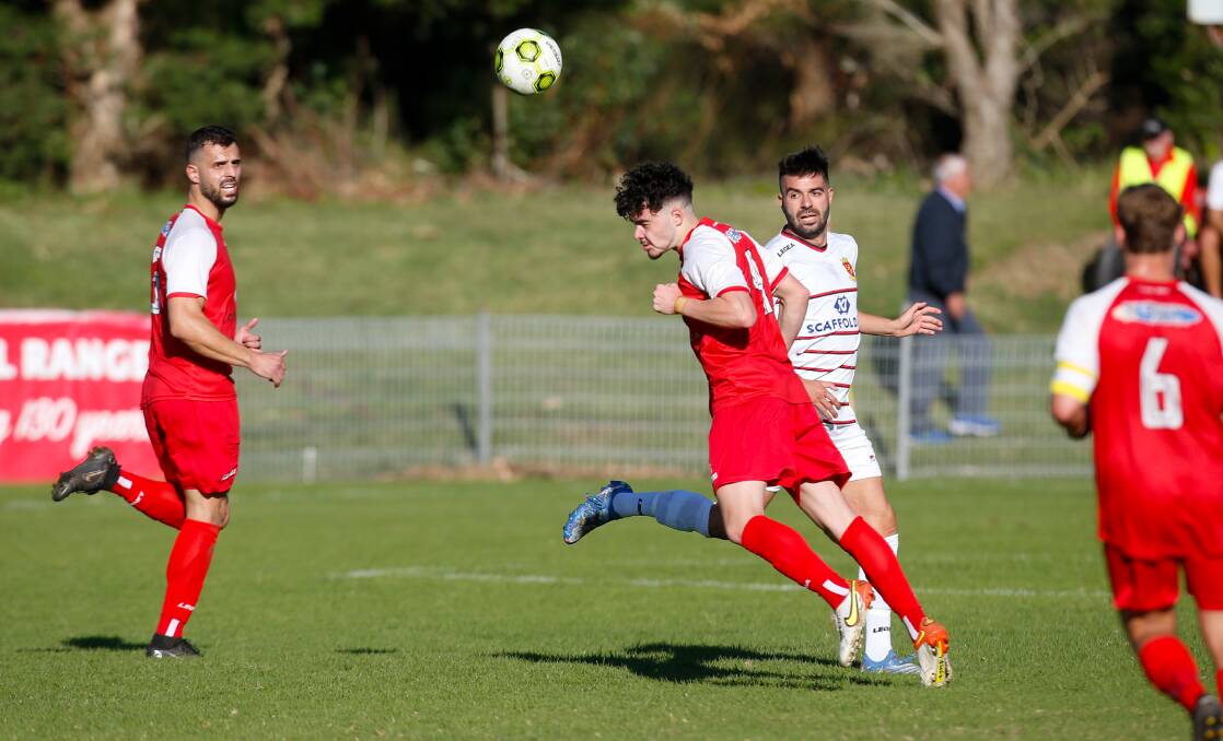 Corrimal defender Luca Papalia heads the ball away from Lions opponent Peter Simonoski during a Premier League game earlier this year. Picture by Anna Warr