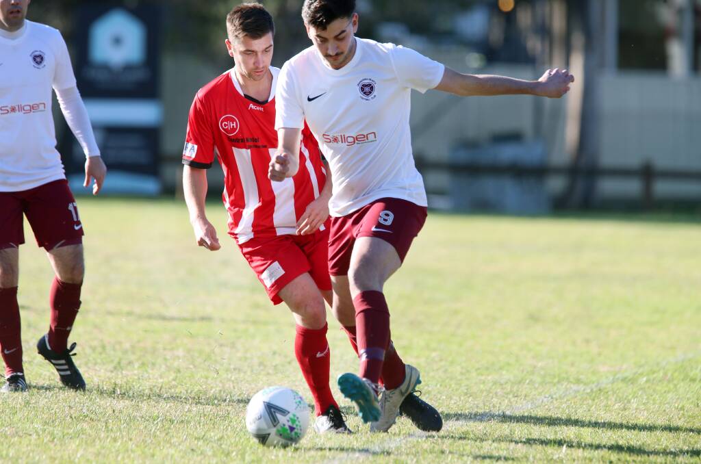 MOVING: Unanderra's Daniel Saverino (right) looks to pass the ball during a game earlier this year. Picture: Sylvia Liber