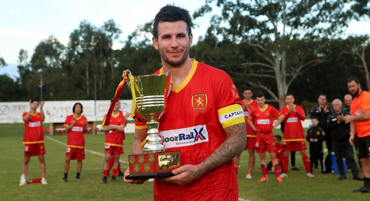 EXCITED: Wollongong United captain James O'Rourke holds up the Frat Cup trophy at Memorial Park on Sunday afternoon. Picture: Sylvia Liber