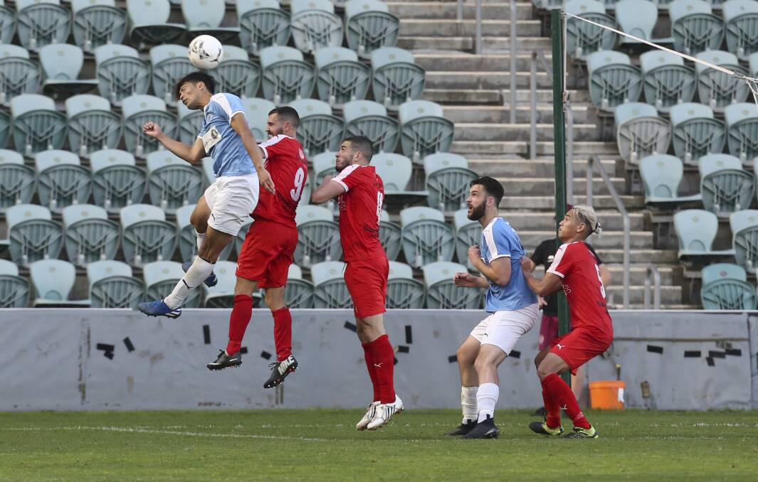 MOVING FORWARD: Wollongong Olympic's Yusuke Ueda jumps highest to head the ball during last year's Premier League grand final against Corrimal. Picture: Anna Warr