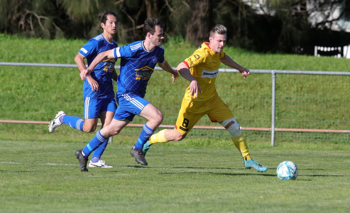 WORKING HARD: United's Dinko Terzic leads Bulli opponent Kyle Jackson in the chase to the ball at Macedonia Park on Sunday. Picture: Sylvia Liber