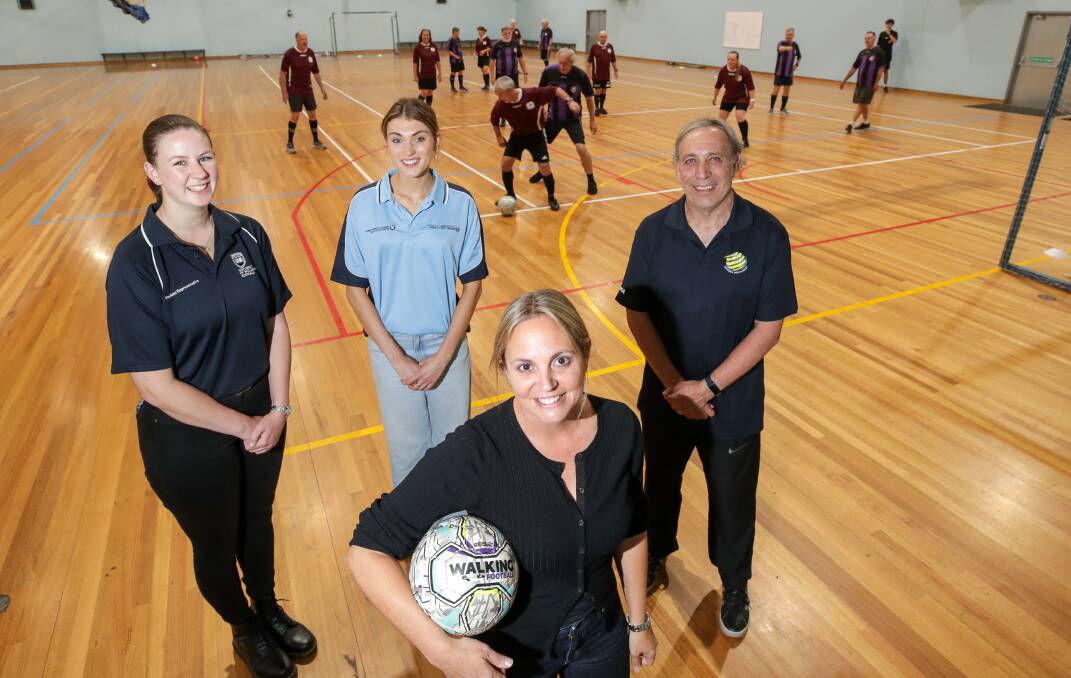 UOW students Nadine Dimmock (left) and Julia McElroy, UOW lecturer, public relations and sports marketing Mercedez Hinchcliff (holding ball) and Football South Coast walking football coordinator Joe Seco helped launch the Walk the Field event on Monday. Picture by Adam McLean
