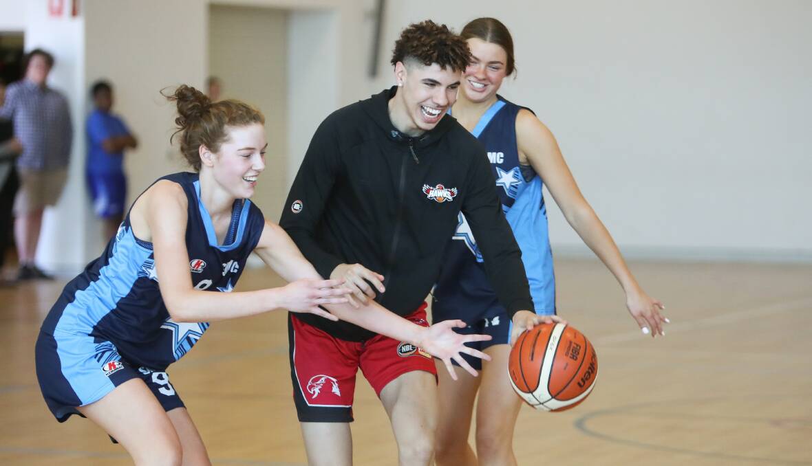 CENTRE STAGE: LaMelo Ball finds his way past Georgia Chrystal-Foy (left) and Audra Pasakarnis. The Illawarra Hawks played an exhibition game against St Mary Star of the Sea College students on Tuesday. Picture: Adam McLean 