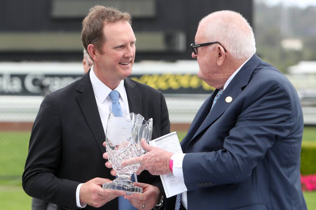 Illawarra Turf Club Chairman Barry Vandenbergh (right) presents the silverware to Michael Hawkes after Archedemus won The Gong race on Saturday. Picture: Adam McLean