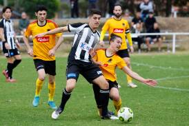 Port Kembla's Sebastian Tomasiello (left) battles with a Coniston opponent for possession during a Premier League game last year. Picture by Anna Warr