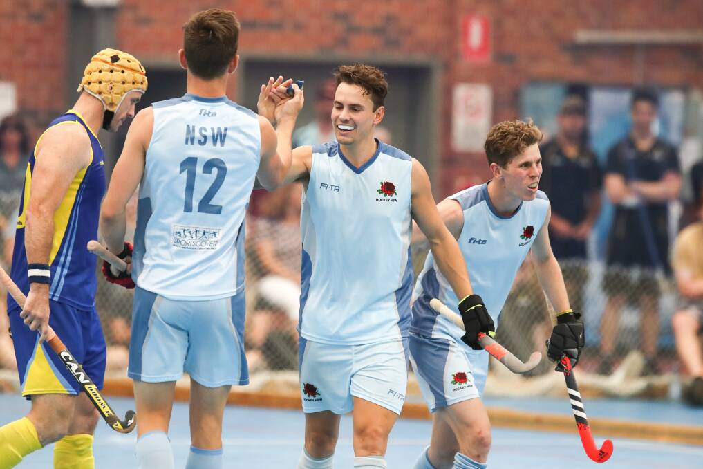 HAPPY: Albion Park's Jack Hayes (centre) high fives a NSW teammate during the Australian Indoor Hockey Festival. Picture: Adam McLean
