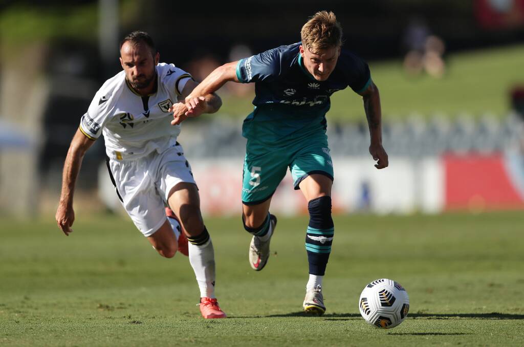 ON THE CHARGE: Phoenix defender James McGarry (right) chases after the ball against Macarthur FC. Picture: Mark Metcalfe/Getty Images