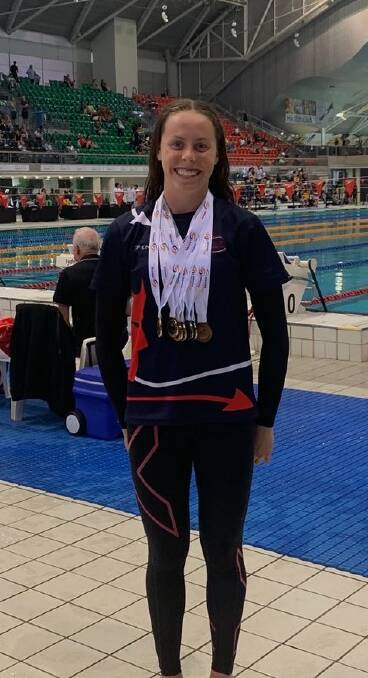 Chelsea Jones proudly displays some of the medals she won at the NSW Swimming Long Course State Championships. Picture: IAS