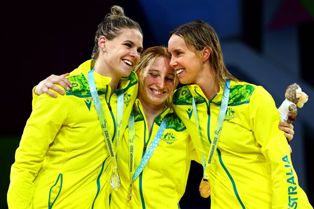 JOY: Silver medallist Shayna Jack, gold medallist Mollie O'Callaghan and bronze medallist Emma McKeon embrace during the medal ceremony for the 100m women's freestyle. Picture: Elsa/Getty Images