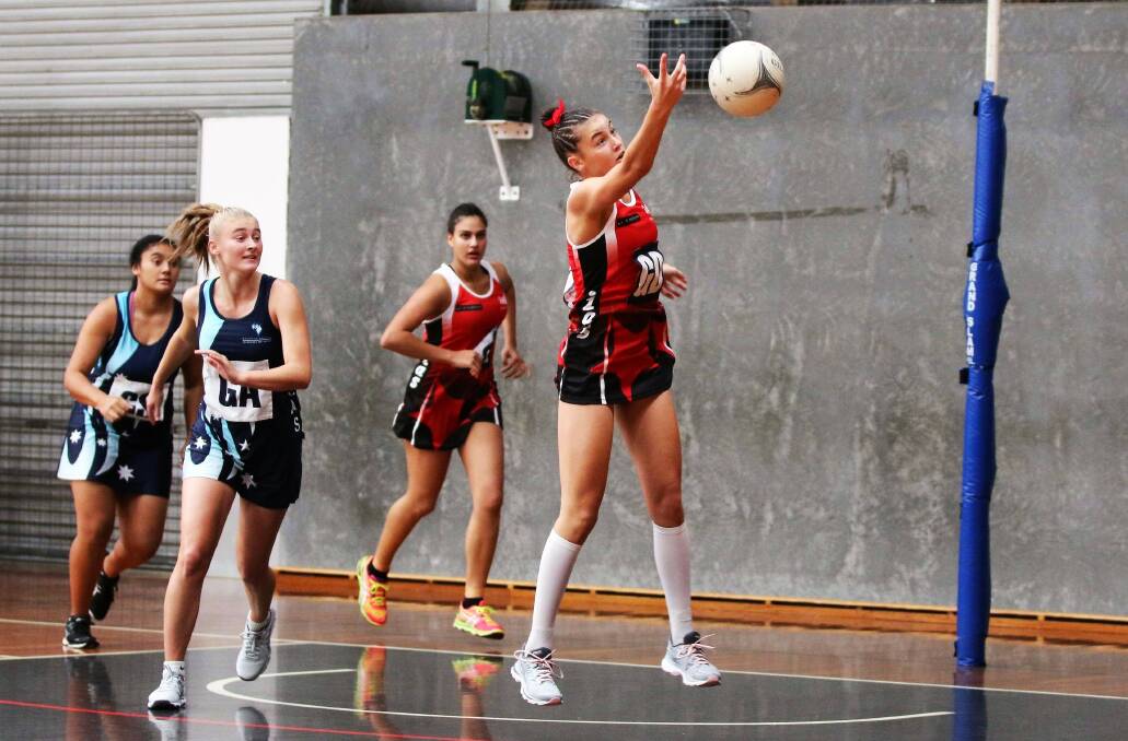 FOCUSED: Sharnee Behr works hard to clear the ball during a game for the Illawarra Academy of Sport. Picture: IAS