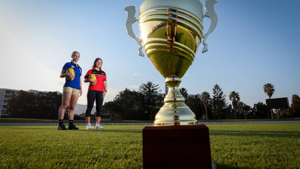 Figtree Saints player Lily Macdonald and Wollongong Lions captain Lauren Myers eye off the trophy ahead of this Saturday's Women's Premier Division grand final. Picture by Adam McLean