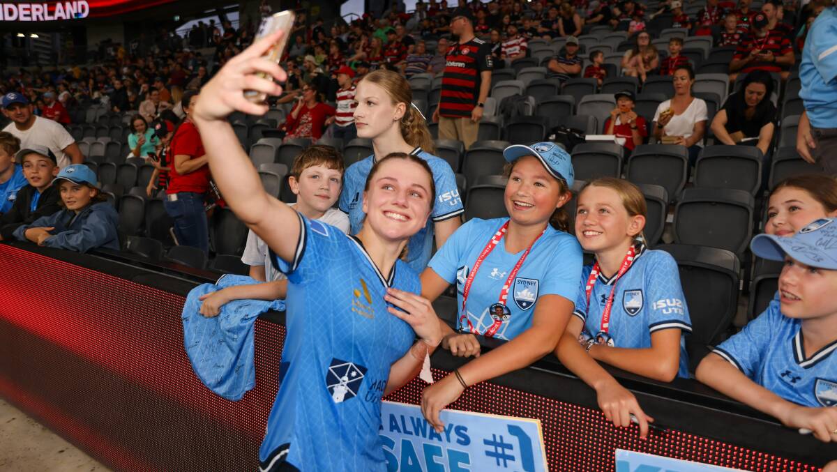 Horsley's Caley Tallon-Henniker poses for a photo with young Sydney FC fans at CommBank Stadium on Saturday night. Picture - Sydney FC