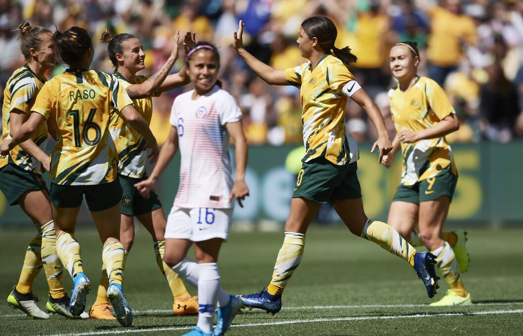 Caitlin Foord (right) watches on as Matildas captain Sam Kerr celebrates scoring a goal with team mates on Saturday afternoon. Picture: Brett Hemmings/FDC