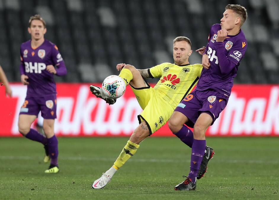 EYES ON THE PRIZE: Wellington's David Ball (left) competes for possession with a Perth Glory opponent. Picture: Mark Metcalfe/Getty Images
