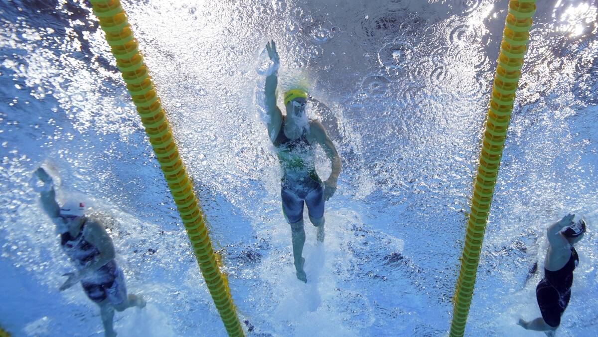 POWERFUL: Australia's Emma McKeon (centre) leads the way in her 100m freestyle heat in Tokyo on Wednesday night. Picture: AP Photo/David J. Phillip