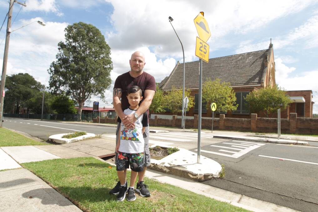 Heath Enguix and his son Byron, seven, at the Lindesay Street school crossing outside St John's Catholic Primary School, where Byron was struck by a car. Picture: Simon Bennett