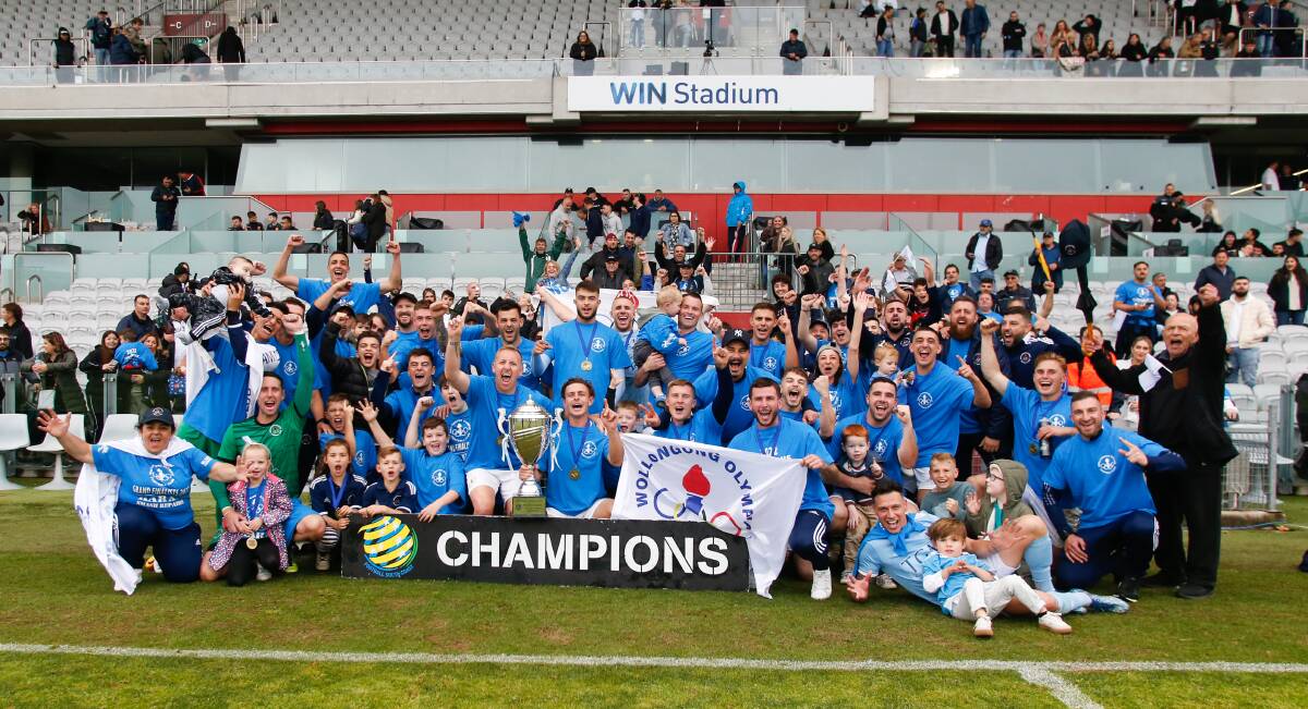 Wollongong Olympic players, coaches and fans celebrate after winning the Premier League grand final. Picture by Anna Warr