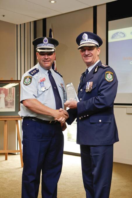 Top cop: Lake Illawarra Local Area Command inspector Steve Johnson receives an  award from then NSW Police Commissioner Andrew Scipione.