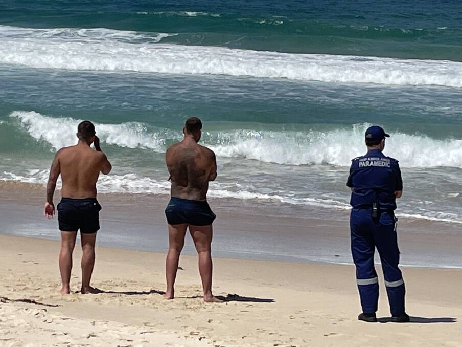 Two swimmers left the water but a third is still in the water. Picture: Robert Peet