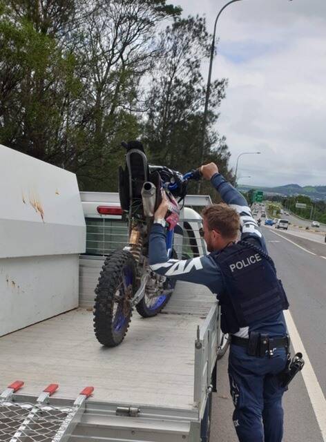 A trail bike unit officer from Lake Illawarra Police District seizing an unregistered trail bike after arresting an unlicenced Albion Park man. Picture: Lake Illawarra Police District