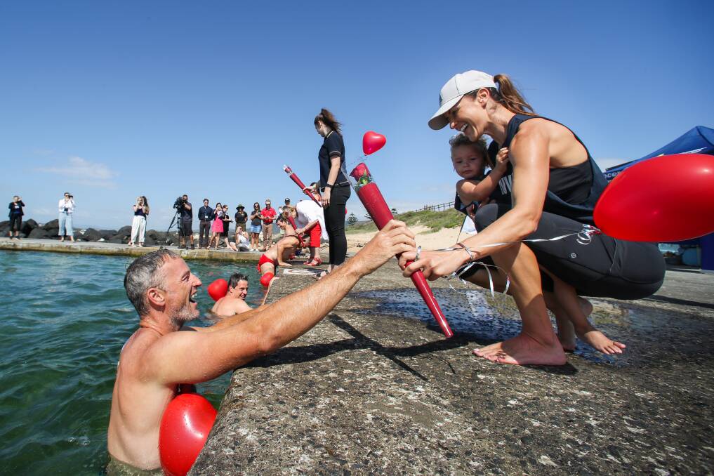 Love wins: Former basketball player Glen Saville handing a rose to his wife Angela during the Valentine's Day launch of the Great Ocean Pool Crawl event. Picture: Adam McLean