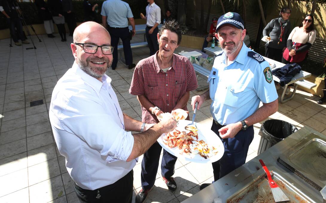 Connected: Patrick Schmidt from Kells Lawyers, Wollongong Homeless Hub client Daniel Ball and Wollongong District Police Sergeant Darren Murray at the Homelessness Week barbeque. Picture: Robert Peet