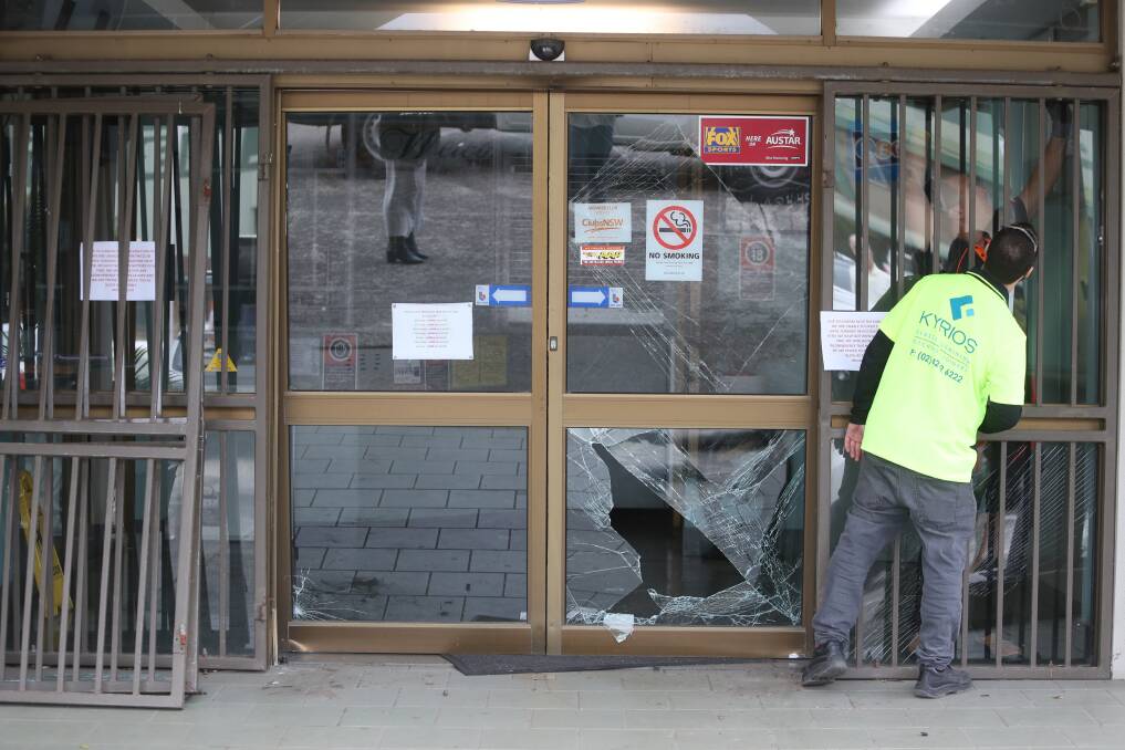 A thief rammed a ute into the front doors of the Kemblawarra Portuguese Sports and Social Club on Monday. Glaziers were on site to fix the doors. Picture: Robert Peet