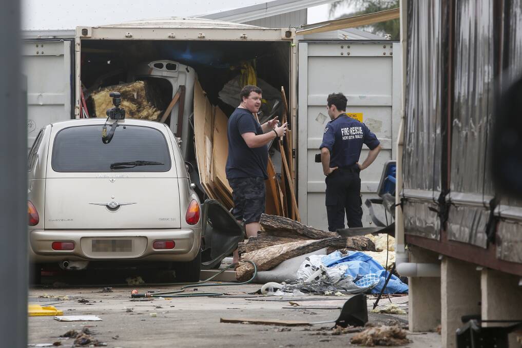 Blast: Investigators on Saturday at the scene of an explosion in a shipping container at the rear of a house at Oak Flats that seriously injured two people. Picture: Anna Warr