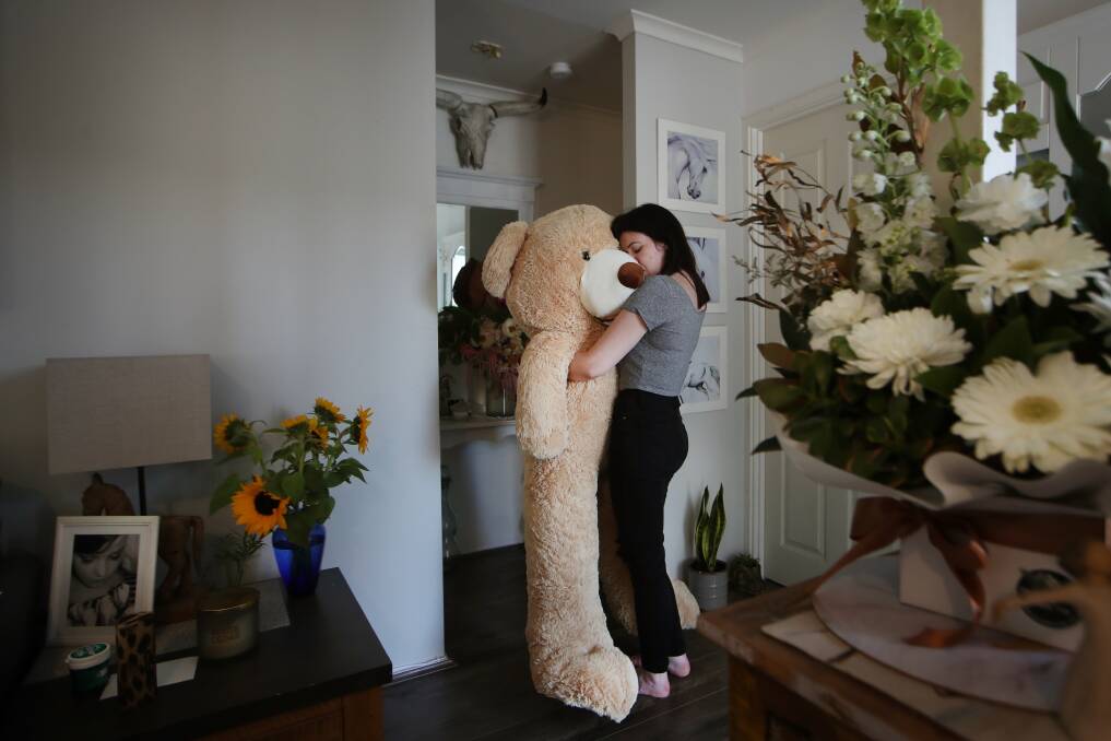 Libby's sister Stevie hugs a life-size bear Luke gifted his girlfriend. Mrs Ruge remembers walking with it around the shops. Picture: Sylvia Liber