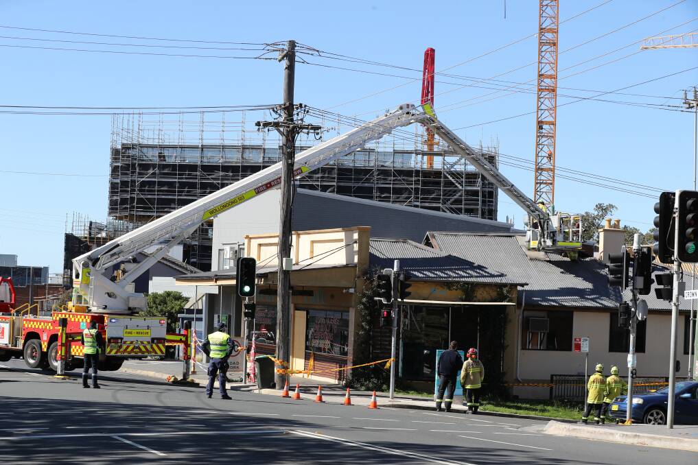 Fire crews working to secure the roof of Meni cafe. Pictures: Robert Peet