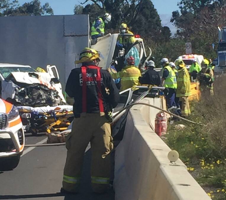 Fire crews work to free the trapped driver. Picture: Zoe Cartwright