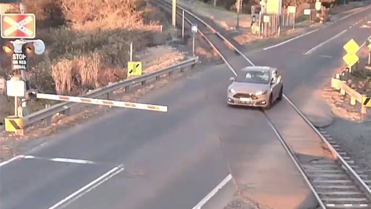 A car narrowly misses a train as it illegally crosses through a level crossing in Kembla Grange. Picture: NSW Police
