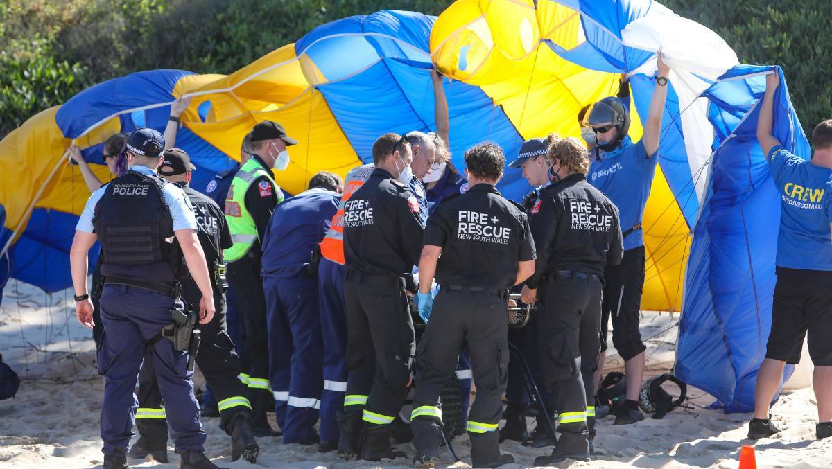 Emergency services personnel took care of one of the skydivers hurt following a crash landing on North Wollongong beach. Picture: Adam McLean