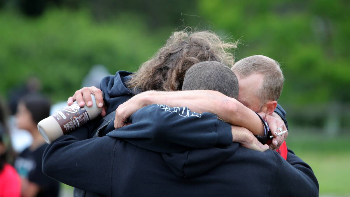 Friends embrace to support each other at the small gathering on Sunday. Picture: Sylvia Liber