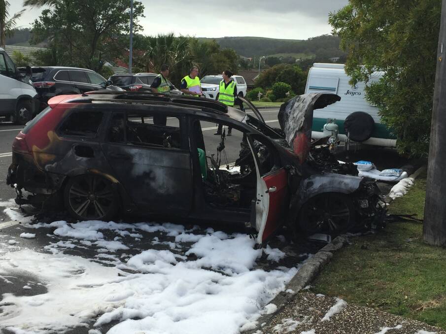 Damaged: Police at the scene of a fiery car crash at Albion Park. A female passenger was taken to hospital. Picture: Brendan Crabb