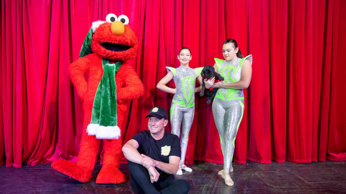 Sesame Street Circus director Keith Brown, centre, with Elmo, and acrobat sisters Naiema and Amina Jratlou (and Bambi the poodle). Picture: Sitthixay Ditthavong