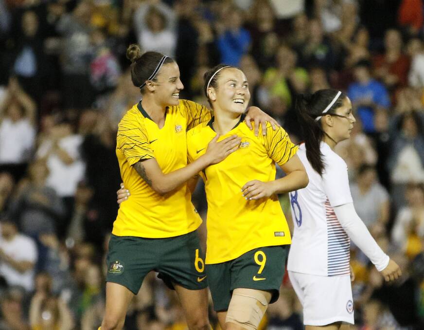 HAT-TRICK HERO: Caitlin Foord (right) celebrates after scoring against Chile on Tuesday night. Picture: Darren Pateman (AAP)